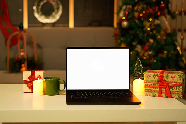 istock Blank display screen laptop computer on white wood table. Modern cozy comfortable home living room with Christmas decor. Home office desk workspace. 2244277413