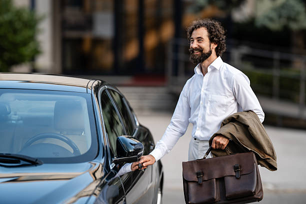 istock Smiling businessman opening car door after work 2244277633