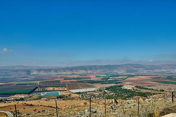 istock Panoramic view of agricultural fields and distant mountains under a clear blue sky, showcasing rural landscapes and natural beauty 2244279087