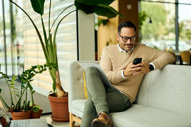istock Relaxed Professional Man On Couch Using Smartphone In Modern Office Lounge Setting During Break At Work 2244280329