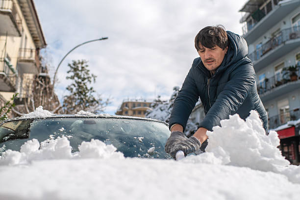istock Man cleaning his car after heavy snowfall 2244281960