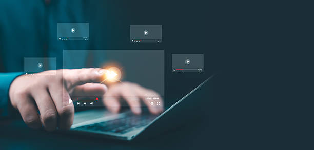 istock Businessman using laptop and touching virtual play button with glowing digital video icons, representing online media, streaming, marketing, content creation, technology, and modern communication. 2244284546
