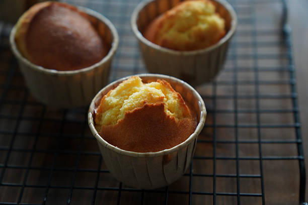 Freshly baked cupcakes cooling on a metal rack, showcasing their golden-brown tops.