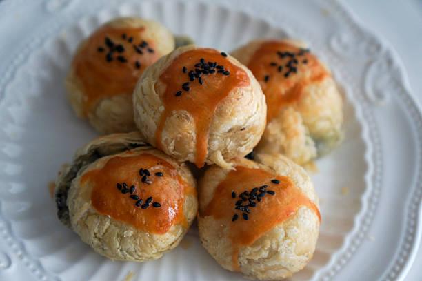 A plate of delicious Chinese pastries topped with sesame seeds, showcasing their flaky and appetizing appearance.