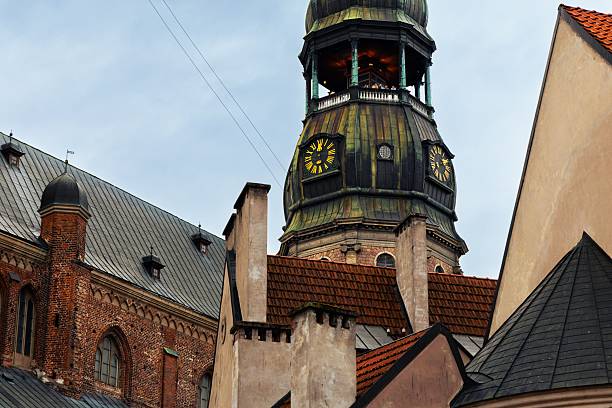 Riga, Latvia – July 31, 2025: Close-up of a historic clock tower in Riga, Latvia, showcasing intricate architecture and a clear sky.