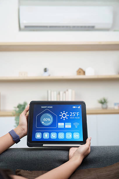 istock Technology. Woman managing smart home features with tablet. 2244290049
