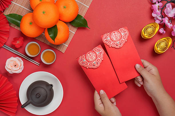 istock Chinese New Year festive setup with oranges and red envelopes 2244290771