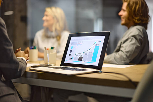 Close up of laptop with chart of progress on it during a business meeting in the office.