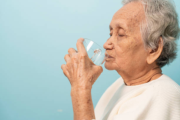 istock An elderly Asian woman drinks clean water from a glass. 2244292144