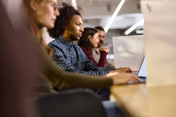 istock Black programmer working on laptop among his colleagues in the office. 2244292279
