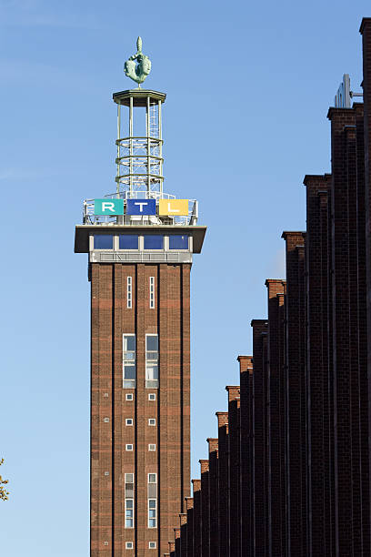 Cologne, Germany October 30 2025: Historic brick Messeturm in Cologne-Deutz, topped by the iconic Hermes sculpture (1928) and modern RTL television signage