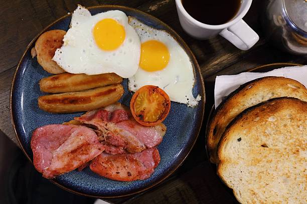Irish breakfast in a cafe in Dublin. Traditional morning meal with sausage, bacon, tomato, fried egg, toast and white pudding.