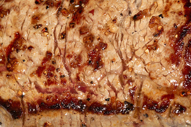 Close up of a cooked grilled steak slice on white background