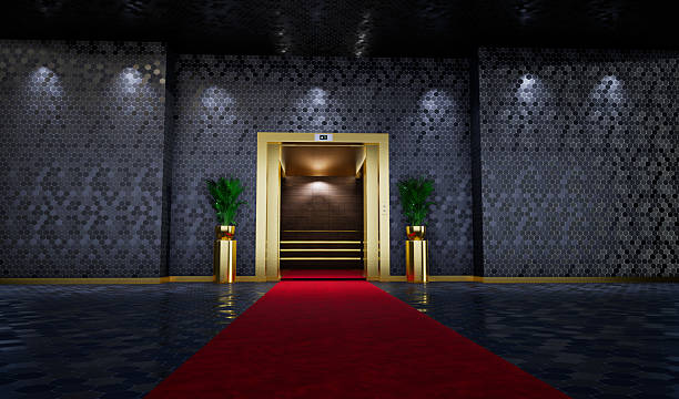 istock red carpet leading to an Open golden elevator in business lobby. 2244297613