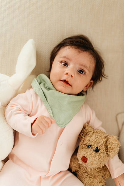 istock Baby with soft toys on couch 2244298270