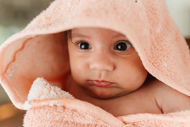 istock Baby in peach hooded towel held after bath 2244298922
