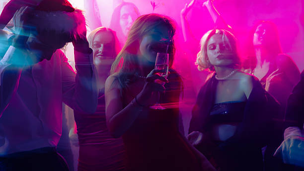 istock New Year celebration with champagne and colorful motion blur under pink light 2244300058