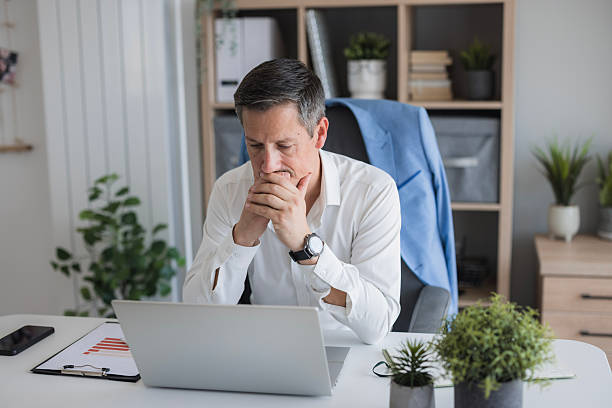 istock Stressed businessman contemplating important financial decisions at office 2244301871