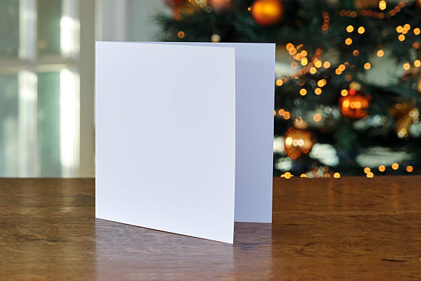 istock Standing blank greeting card mockup in front of a christmas tree 2244303122