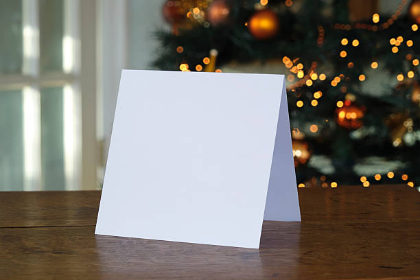 istock Standing blank greeting card mockup in front of a christmas tree 2244303123