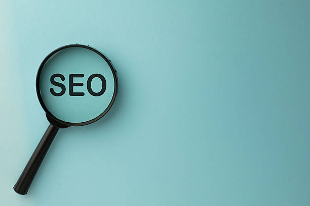 istock SEO (Search Engine Optimization) concept, magnifying glass focusing on the text on a blue background. 2244304183