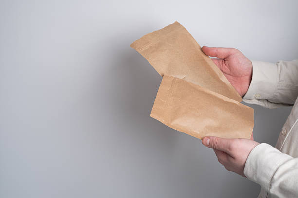 istock Kraft paper packaging in a mans hands. Packaging for coffee, cosmetics. Packing closeup. Product for sale. Online shopping. Boxes with surprise. Delivery service, shipping. Empty, mockup. Eco friendly 2244304808