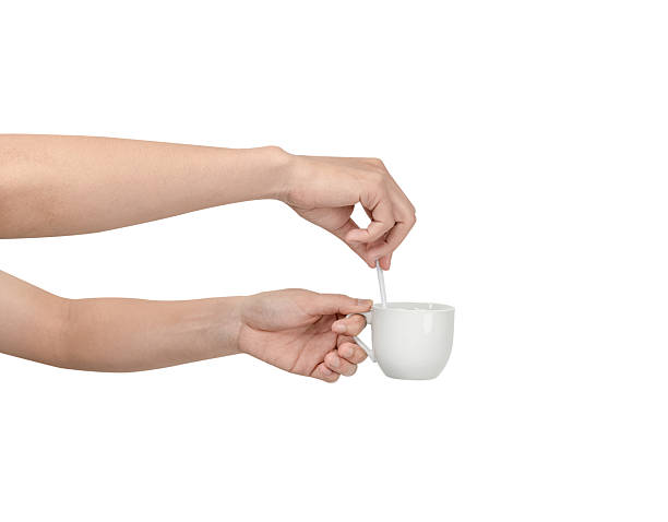 istock A person's hand extending and holding a plain, white ceramic coffee cup with a small white spoon inside. Isolated on a clean white background, this image conveys concepts of service Isolated. 2244306184