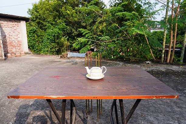 Teapots with saucers on garden tables create elegant outdoor tea time