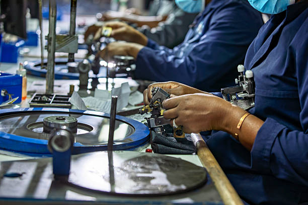 african workers, diamond polisher at work, using a polishing wheel to shape and refine a rough diamond, brillianteering