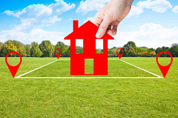 istock Land plot management - real estate concept with a vacant land parcel available for building construction - housing concept with hand holding a little red house in a residential area for sale 2244308195