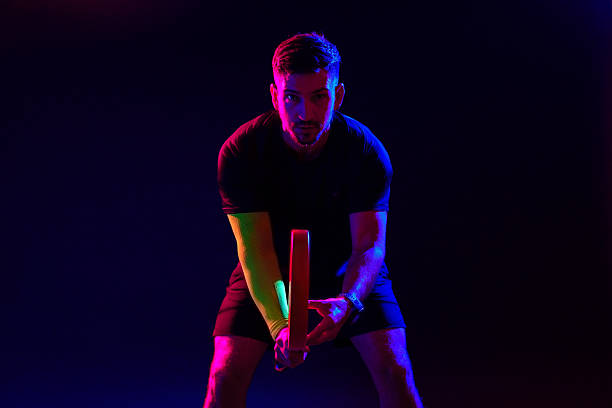 istock Athlete preparing to play table tennis in a dramatic dark setting with colorful lights 2244309404