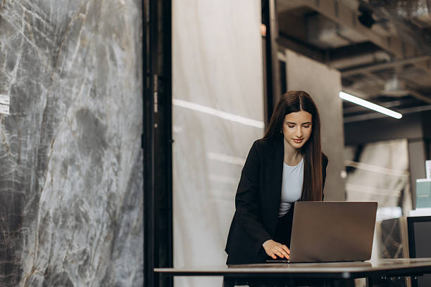 istock Professional Woman in Office Setting Working on a Laptop on a Desk 2244315203