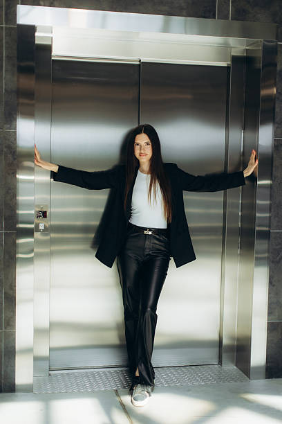 istock Confident Woman Posing at Modern Elevator in Stylish Outfit 2244315243