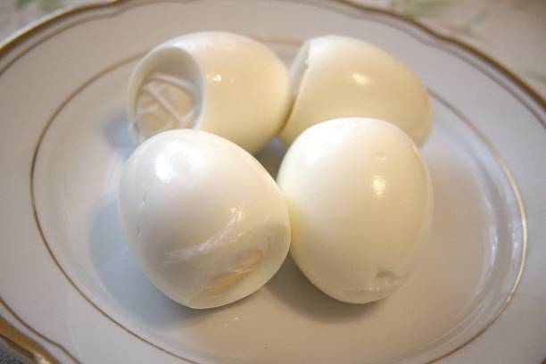 istock Number 4 peeled boiled eggs on a plate, close-up 2244315628