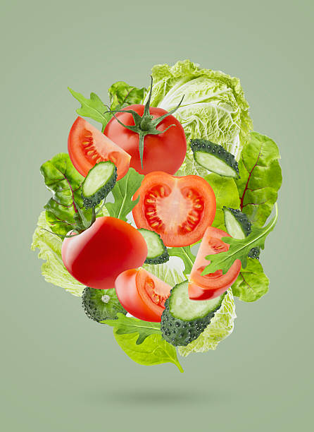 istock Fresh summer vegetable salad background. Salad ingredients -  chinese cabbage, tomatoes, cucumber, leafy greens fly as swirl on green background. Great for farm-fresh produce, culinary advertising. 2244316543