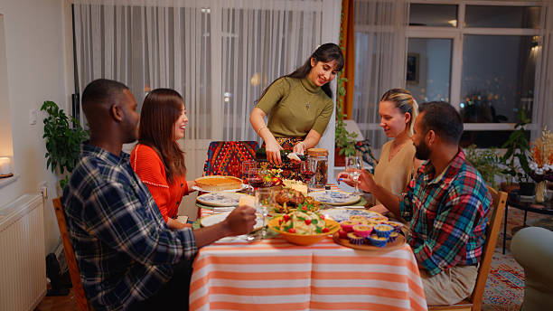 istock Multiracial friends preparing dinner table and meal for dinner party at home 2244316739