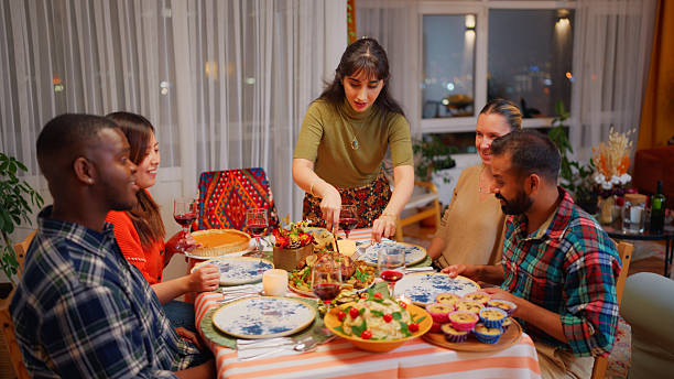 istock Multiracial friends preparing dinner table and meal for dinner party at home 2244317219