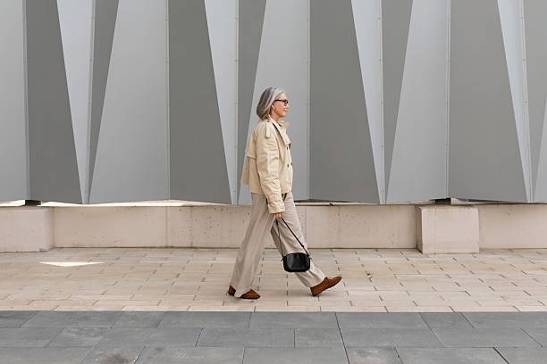 istock Senior woman walks confidently along modern architecture in urban setting under bright daylight 2244317381