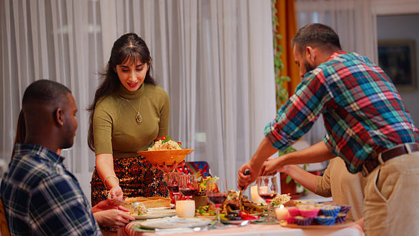 istock Multiracial friends preparing dinner table and meal for dinner party at home 2244319370