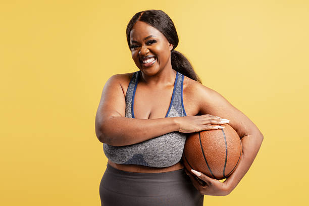 istock Plus size woman holding basketball smiling confidently 2244324953