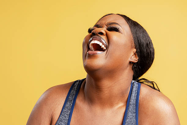 istock Cheerful plus size Black woman laughing on yellow background 2244326149