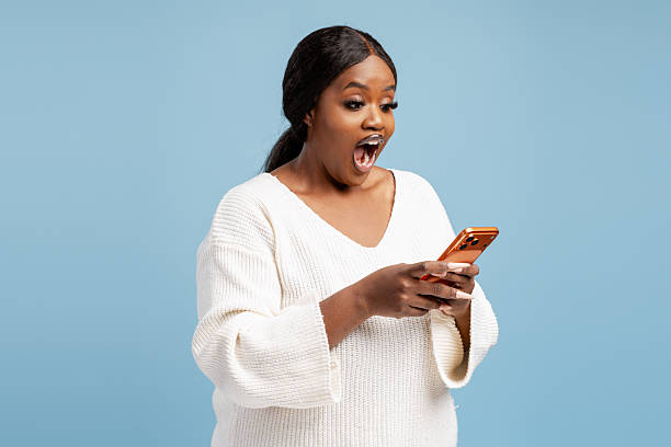 istock Woman feeling surprised while looking at mobile phone 2244326547