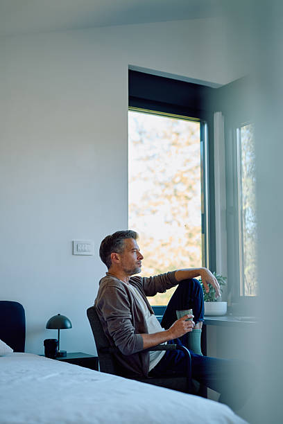 istock Thoughtful man contemplating while relaxing in bedroom 2244326685