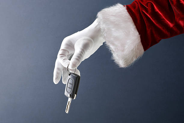 istock Santa Claus hand holding car key isolated on blue background 2244328628