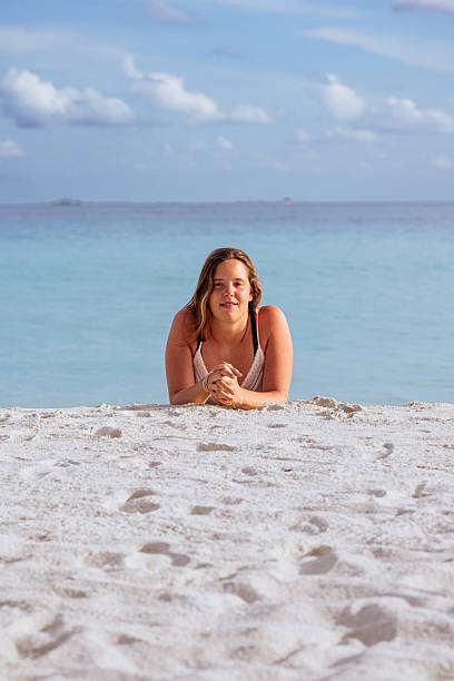 istock Young woman relaxing on clear sand beach vacation 2244329409