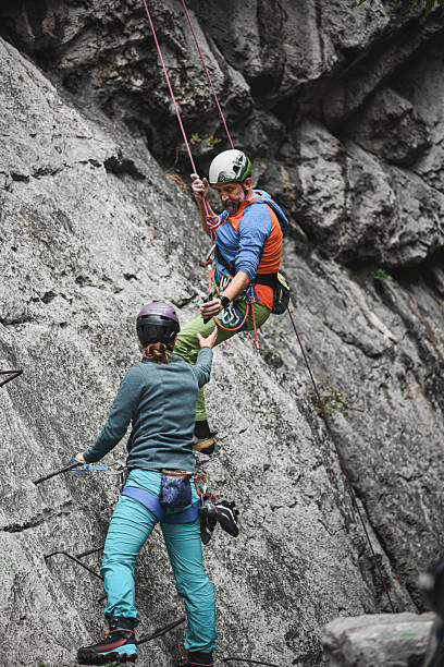 istock Rock Climbing Partners On Cliff Face With Rope Gear And Helmets, Safe Ascent 2244329432