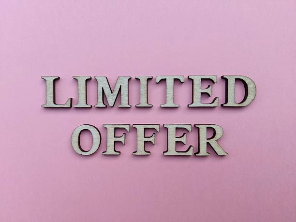 istock Defocused wooden alphabets with text LIMITED OFFER isolated on pink coloured background. Time-sensitive sales or limited-time offers concept 2244331930