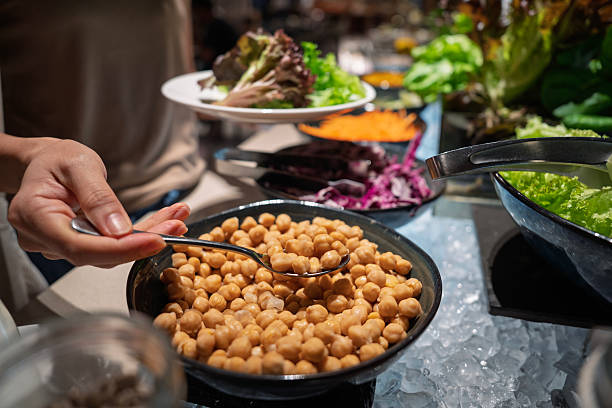 A woman Scooping Chickpeas at Salad Bar