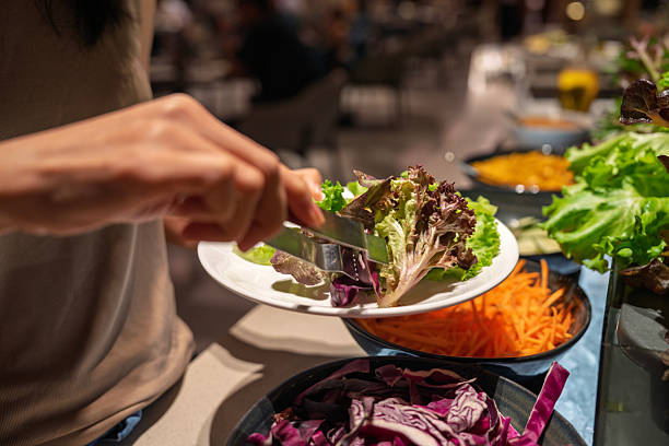 istock A Woman Selecting Fresh Lettuce at Salad Bar 2244337737