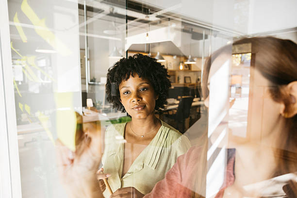 istock Woman collaborating on glass wall in modern office 2244337745